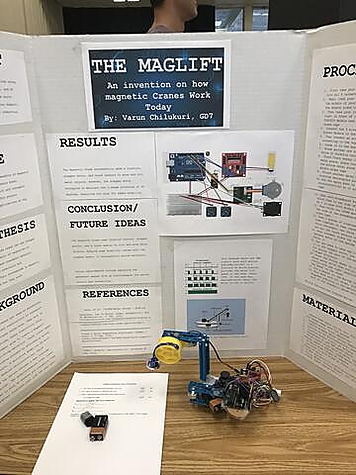 MagLift science fair presentation board with the magnetic crane prototype